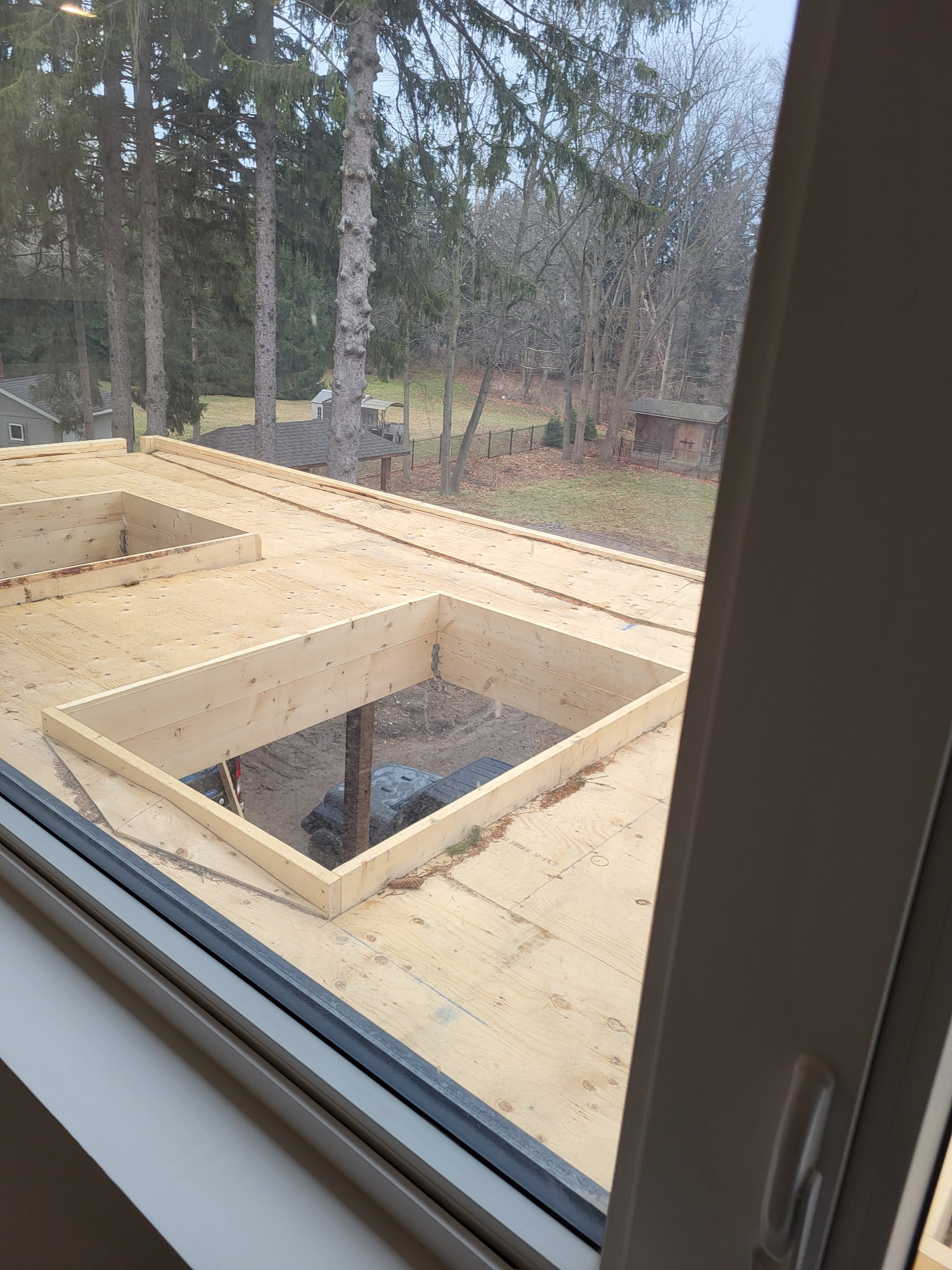 New home addition with roof framing and skylight openings under construction
