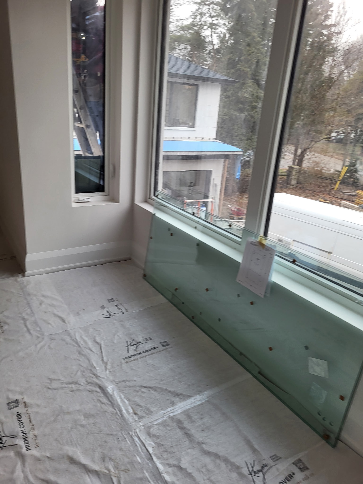 Large corner window installation with floor protection during renovation